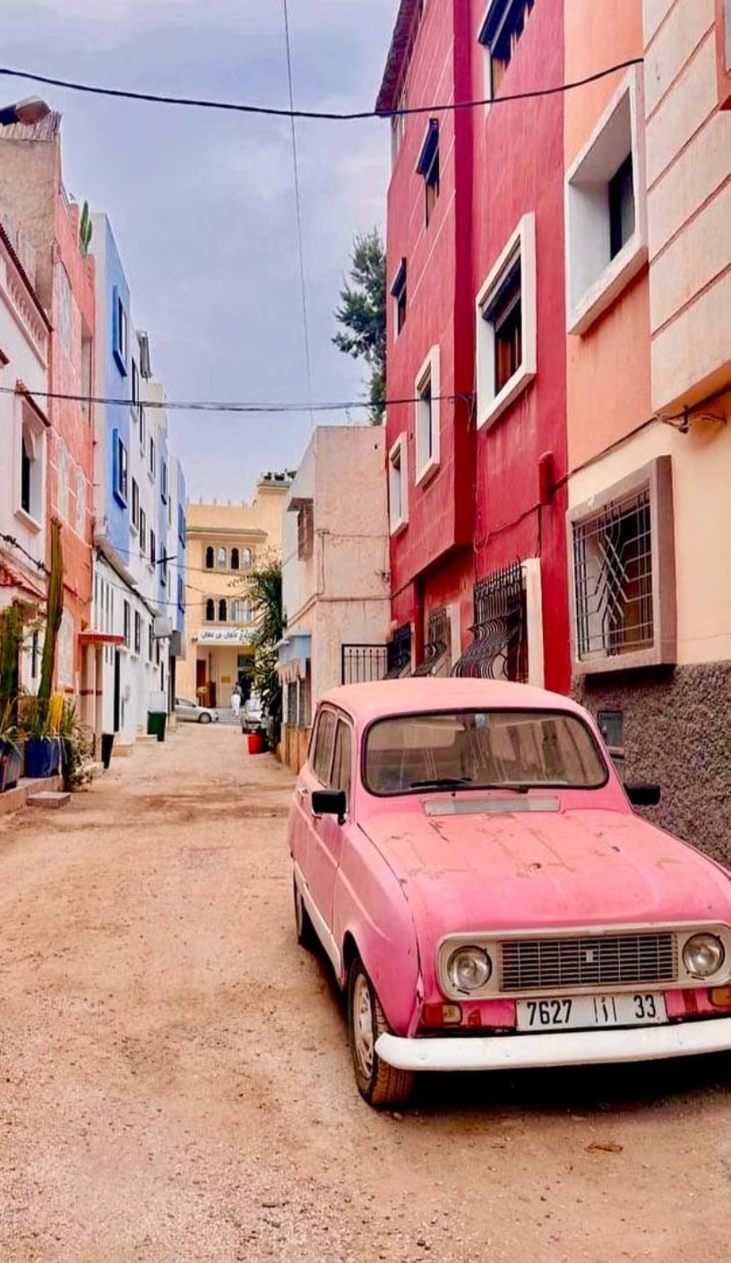 Colorful street in Tamraght village with a vintage pink car
