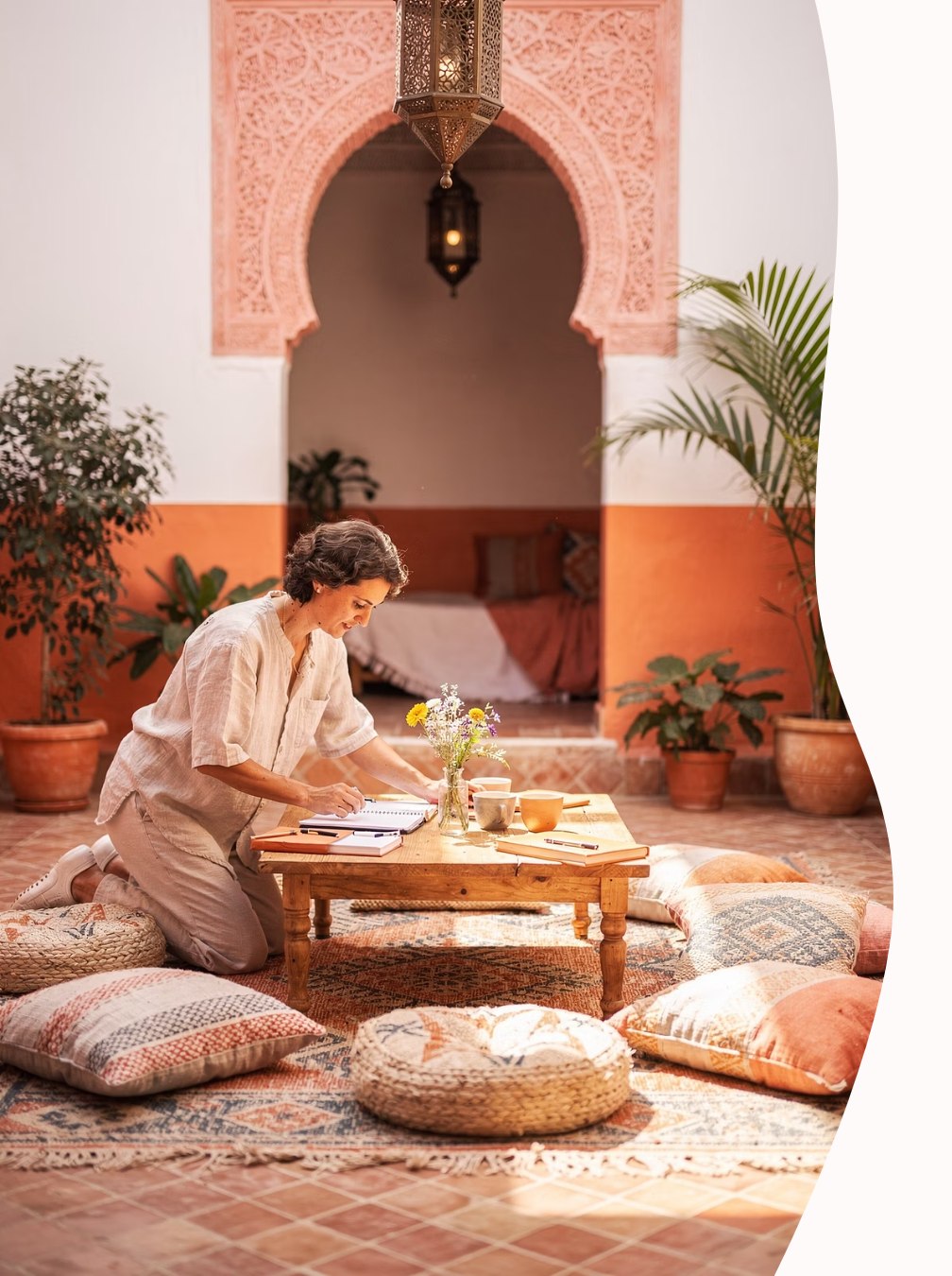Woman journaling in a sunlit Moroccan courtyard